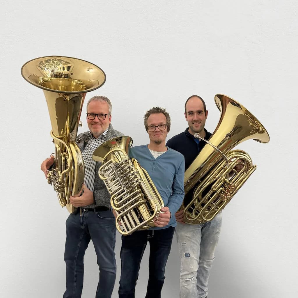 Drei Tubisten von Poco Brass mit ihren Instrumenten